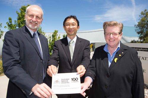 ANU Professor Matthew Colless, The Embassy of Japan's deputy head of mission, Akira Imamura and Centenary creative director Robyn Archer with a replica of the flag.
