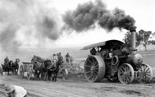 Traction engine towing a road grader loading wagons