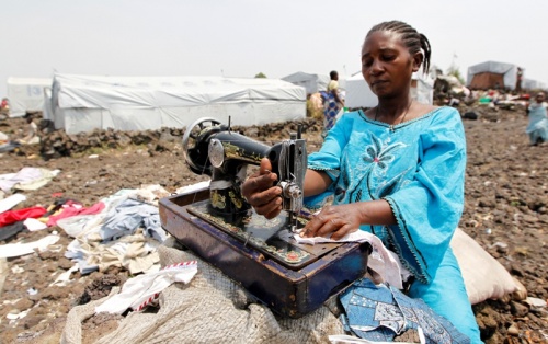  A Congolese woman displaced by recent fighting in North Kivu sews clothes at the Mugunga