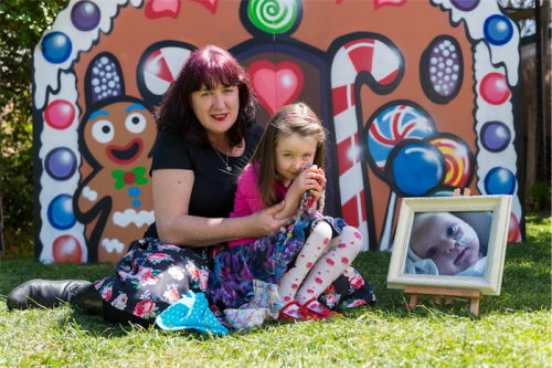 Suzanne Tunks and daughter Ruby, four years, with a photo of baby Stella… “We just started it and found that there were lots of families keen to be involved with the beads program.”  Photo by Andrew Finch