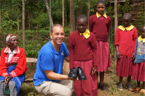 Simon Carroll presenting new school shoes to a sponsored child at the Riamabana Orphanage Academy … "When children in Africa didn’t get an education, they had little chance of getting a job and little chance of getting out of poverty.” 