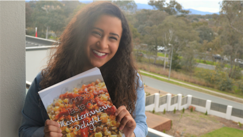 Cookbook co-author Farah Khairat with a copy of “Minnie’s Taste of Mediterranean Delight”. 