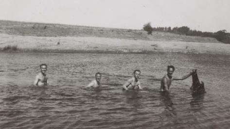 Swimming in Canberra in 1945 oblivious of “a large, amphibian dog-like creature”.
