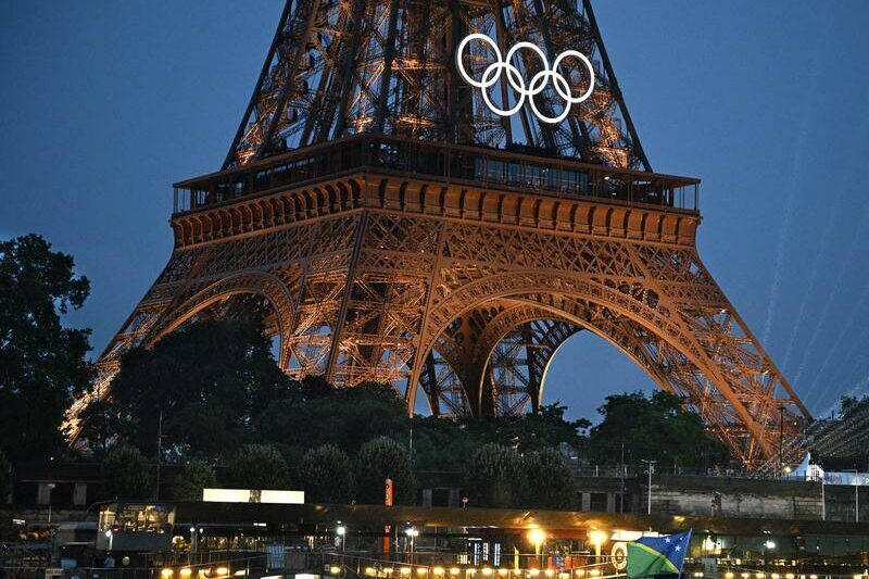 Flame soars, rain falls in historic Paris Games opening